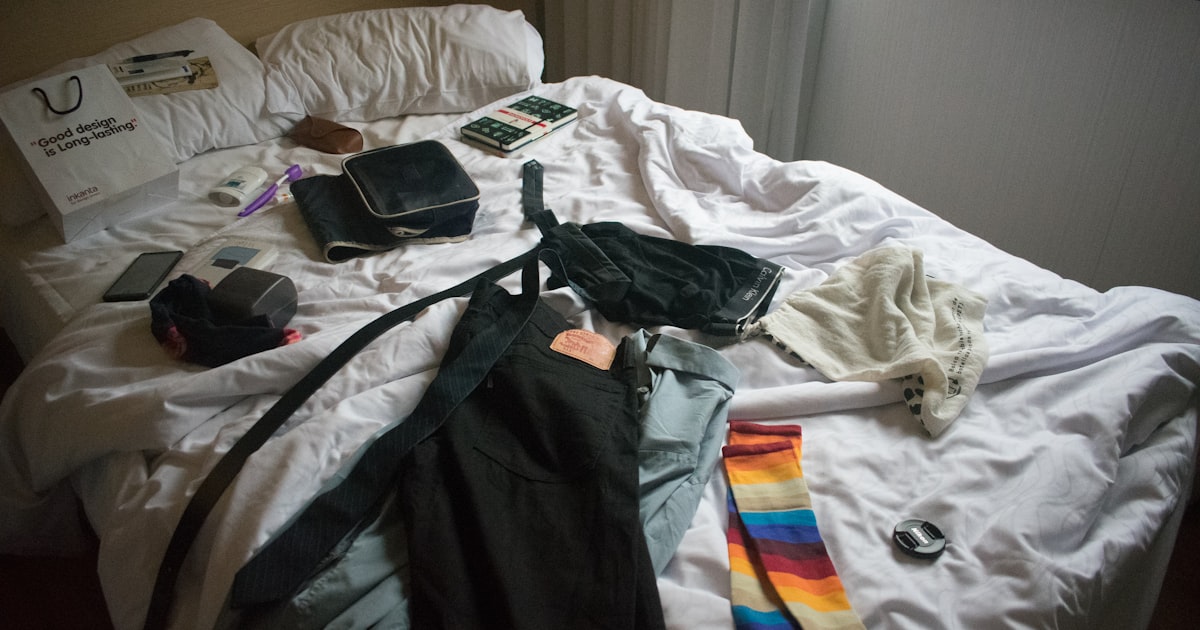two blue and black jeans on bed
